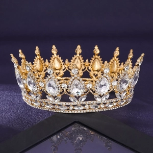 Detailed view of luxury gold bridal crown with sparkling rhinestones on black surface