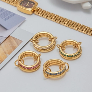 Set of four stackable gold rings with pink blue green and clear zircon stones