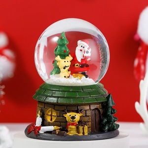 Macro shot of Christmas crystal ball with Santa Claus and reindeer figurines inside
