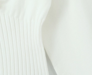 Close-up of white ribbed knit fabric texture showing premium elastic craft and stitching