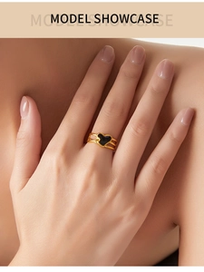 Vue détaillée d'une bague double couche dorée ornée d'un pendentif cœur en émail noir