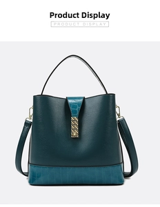 Detail of dark green and blue bucket bag with textured leather and gold metal clasp