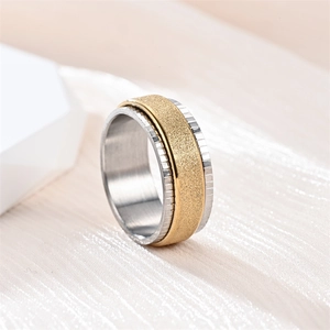 Detail view of a rotating titanium steel spinner ring with a gold frosted center band.