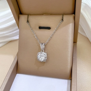 Macro shot of a titanium steel zircon necklace with a sparkling round pendant in a gift box