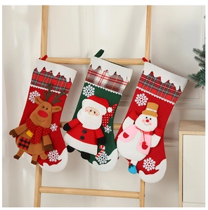 Drei festliche Weihnachtsstrümpfe mit Weihnachtsmann und Rentier an einer Holzleiter aufgehängt