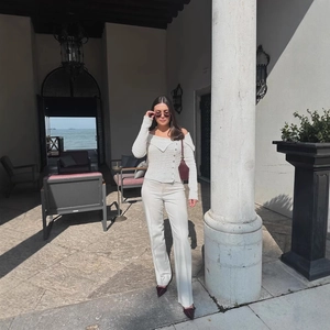 Set maglia bianca con spalla scoperta e pantaloni dritti con dettaglio bottone chic