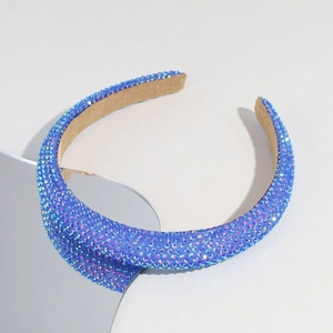 Detailed close-up of blue rhinestone headband with non-slip suede lining for party wear