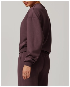 Détail de la texture d'un sweat-shirt à col rond violet foncé et pantalon assorti