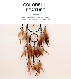 Detail of bohemian dream catcher with brown feathers, red beads, and natural grid weaving