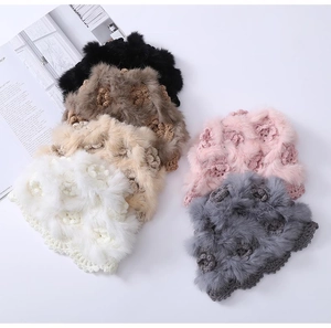 Detail of colorful handmade crochet winter hats with floral patterns and soft fur trim