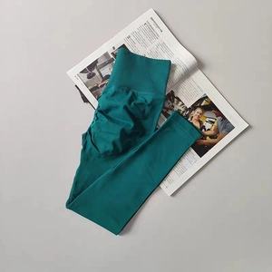 Flat lay of high-waist yoga pants with ribbed waistband and fitness magazine detail