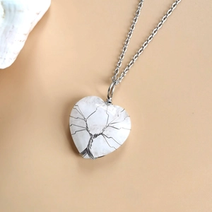 Detail showing handmade silver wire life tree wrapped around heart crystal pendant