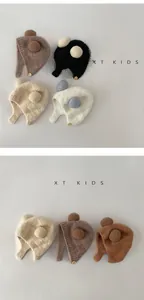Detail of warm baby winter hats featuring plush pom-poms and rustic button accents