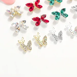 Amuletos de mariposa para uñas con piedras K9 coloridas y detalles de circón sobre blanco