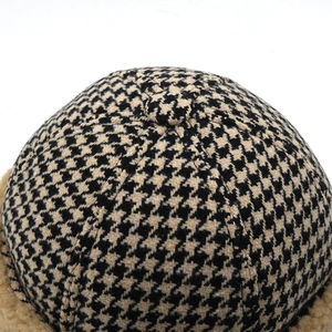 Detailed view of houndstooth knit pattern and soft beige faux fur lining on winter hat