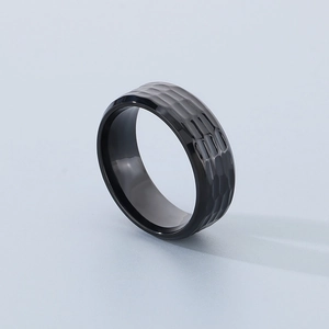 Macro shot of men's black titanium ring featuring a unique hammered texture surface