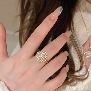 Detail showing rose gold clover ring and necklace set with zircons and pearls