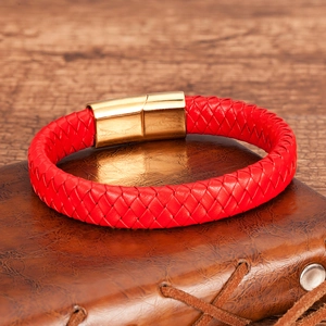 Macro shot of red braided leather bracelet with golden magnetic clasp on brown diary