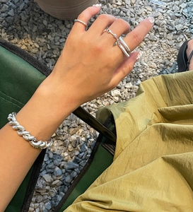 Detailed outdoor shot of 925 silver chunky Cuban chain bracelet and minimalist rings
