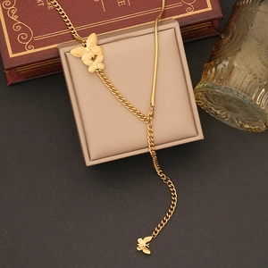 Elegant gold butterfly tassel necklace displayed on a beige jewelry gift box