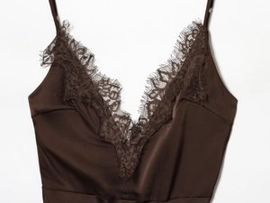 Détail de la robe en satin marron foncé avec dentelle délicate au décolleté et bretelles