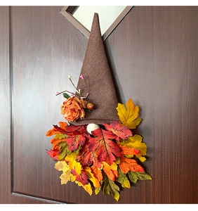 Close-up of autumn gnome door wreath with pointed burlap hat and vibrant maple leaf beard