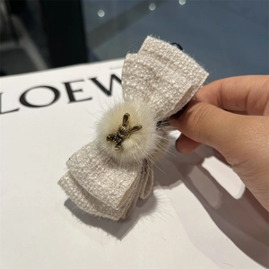 Elegant off-white tweed bow hair clip with gold rabbit charm and plush ball detail