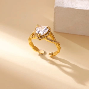 Detail of gold open ring featuring heart-shaped zircon stone and sparkling pavé accents