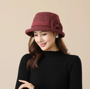 Detailed side view of burgundy houndstooth bucket hat with a stylish bow decoration
