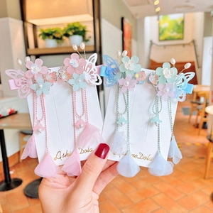 Close-up of cute children flower hair clips with long tassels and pearl butterfly detail