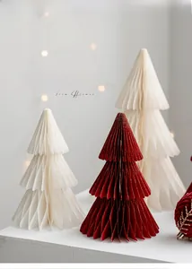 Macro shot of accordion folding paper Christmas trees with red velvet ornaments