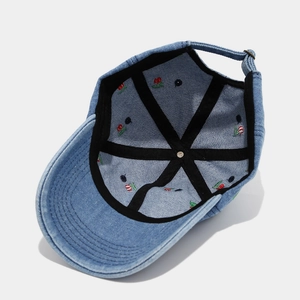 Detail of cherry embroidery on the inner lining of washed denim baseball cap with metal buckle