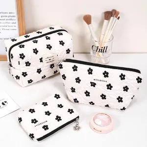 Quilted white cosmetic bag set with cute black flower pattern and zipper closure