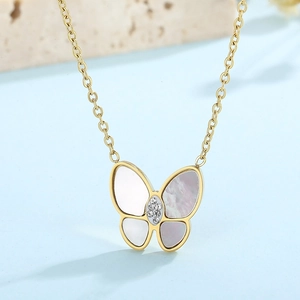 Detailed view of a gold butterfly necklace featuring white shell wings and crystals