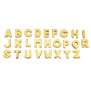 Complete set of 26 shiny gold metal sliding alphabet beads from A to Z on white background
