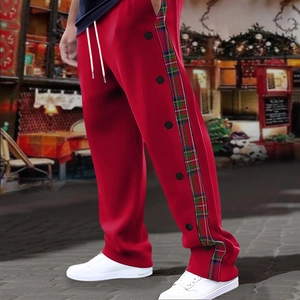 Detail view of red joggers featuring classic plaid side stripes and black snap button closures