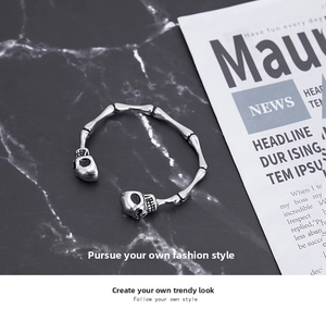 Macro shot of vintage silver skull bone bracelet detail on black marble surface
