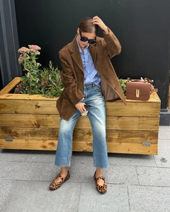 Chic burgundy suede blazer paired with denim jeans and leopard print flats on a street setting