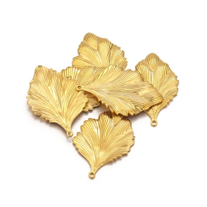 Detailed view of five gold stainless steel leaf charms with intricate leaf vein textures