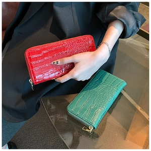 Detail of red and green crocodile pattern long zip wallets with gold hardware accents