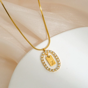 Close-up of gold snake chain necklace with Z letter pendant and crystal oval frame