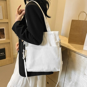 White canvas tote bag showing dual front pockets and versatile shoulder straps