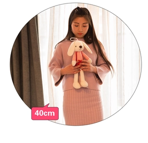 Detail of 40cm white plush bunny with long ears and pink striped outfit for size reference