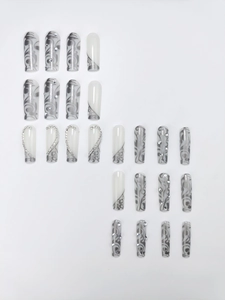 Detail of long coffin press on nails with grey marble texture and silver heart rhinestones