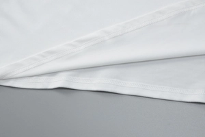 Detailed close-up showing double-needle stitching on the white dress hem fabric
