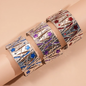 Detail of wide metal cuff bracelets featuring colorful enamel star patterns in red and blue