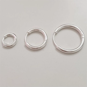 Three-piece set of minimalist silver hoop earrings in small, medium, and large sizes