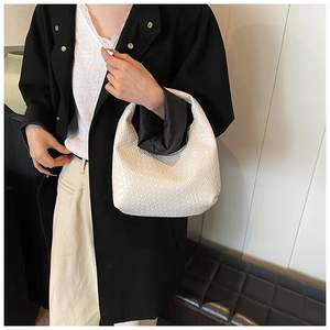 Detail of white woven leather hobo bag with intricate texture and minimalist crescent shape