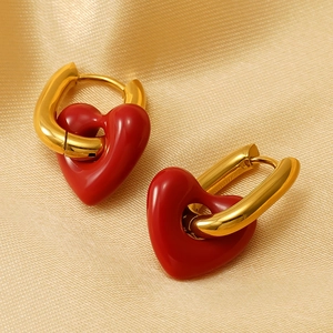 Vintage red heart enamel earrings with golden U-shaped hoops on champagne silk