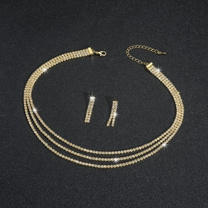 Detailed view of 3-layer gold rhinestone necklace and sparkling tassel earrings set